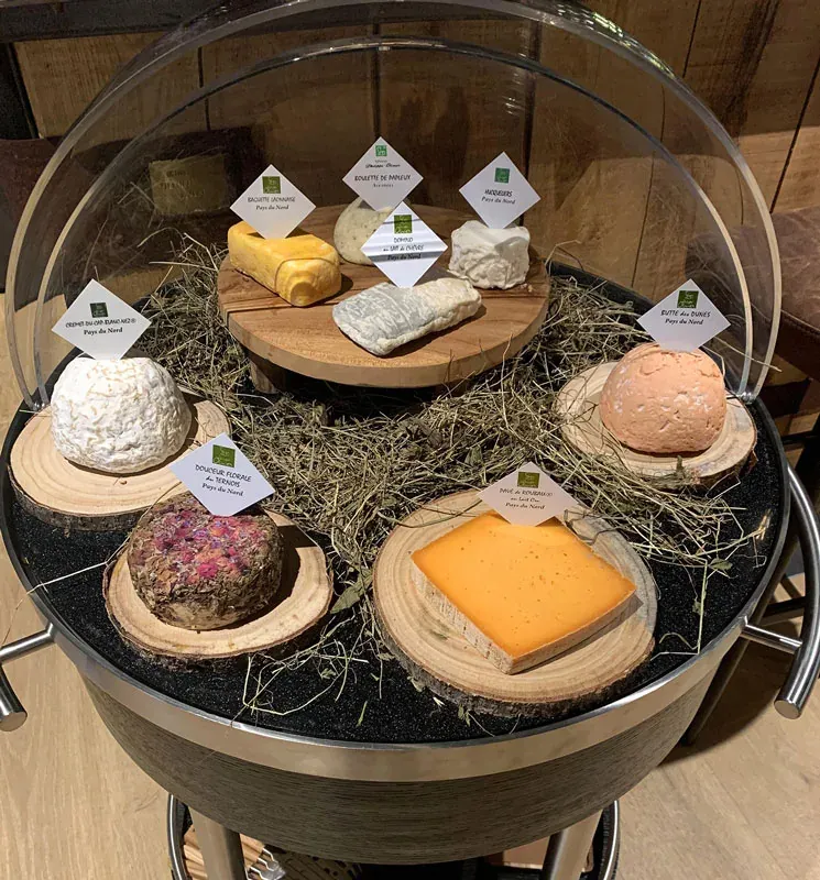 Le chariot à fromages, sous cloche, garni de fromages du Nord sur un lit de foin